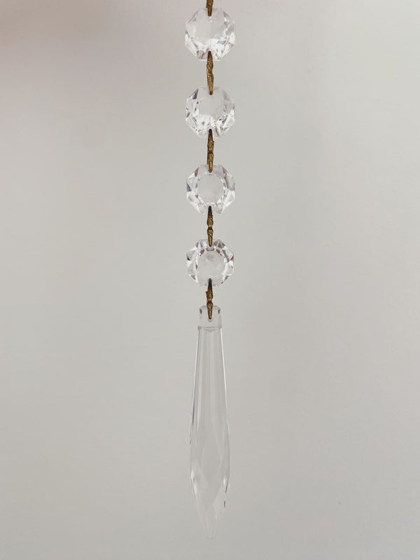 Crystal hanging decoration with teardrop shape on a plain background